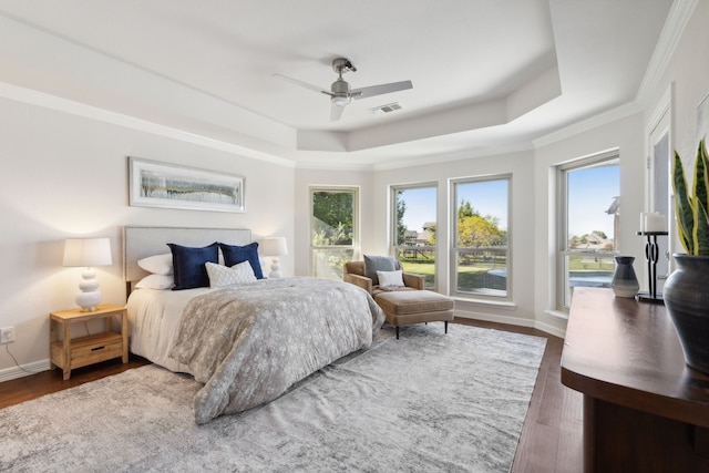 bedroom with dark hardwood / wood-style floors, a raised ceiling, ceiling fan, and crown molding