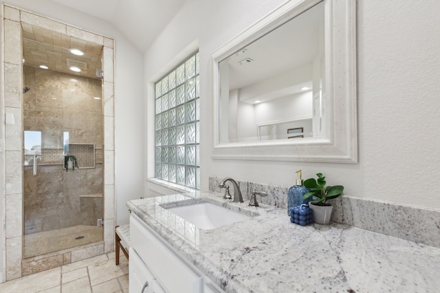 bathroom featuring vanity, an enclosed shower, and lofted ceiling