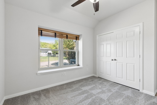 unfurnished bedroom with ceiling fan, light colored carpet, lofted ceiling, and a closet