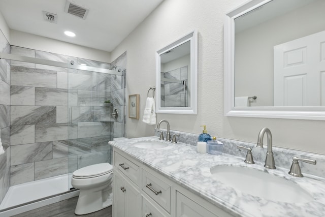 bathroom with hardwood / wood-style floors, vanity, toilet, and an enclosed shower