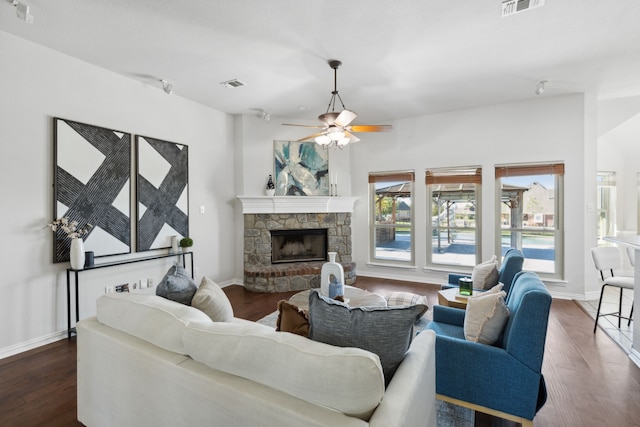 living room featuring dark hardwood / wood-style flooring, ceiling fan, and a fireplace