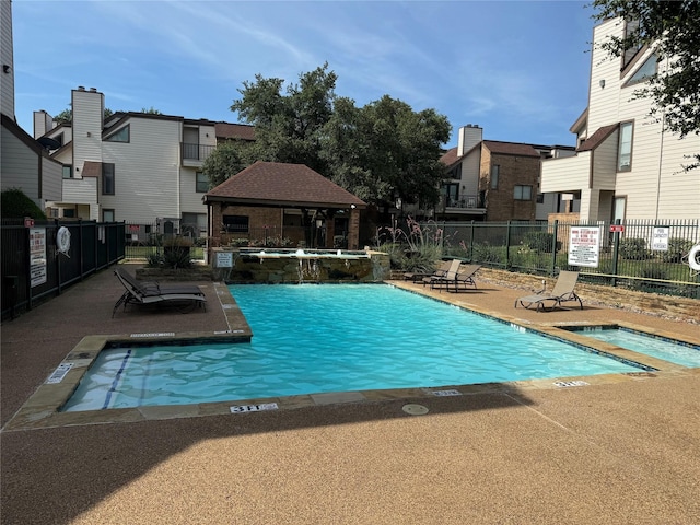 view of pool with a gazebo, a patio area, a community hot tub, and pool water feature