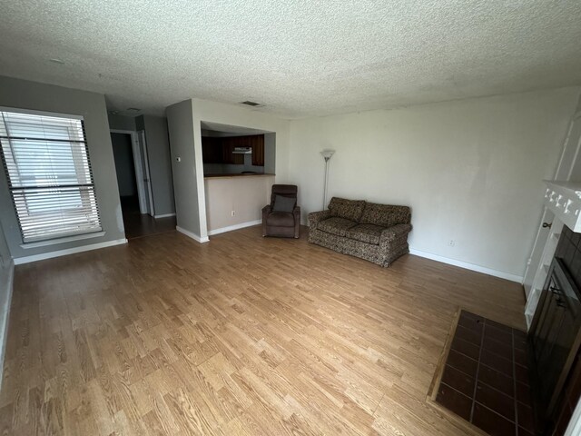 unfurnished living room featuring light hardwood / wood-style floors and a textured ceiling