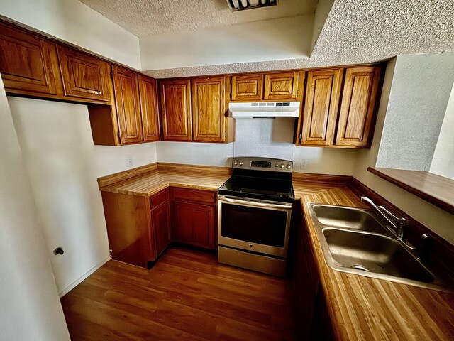 kitchen featuring a textured ceiling, electric range, dark wood-type flooring, and sink