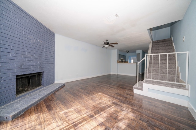 unfurnished living room featuring a fireplace, ceiling fan, and dark wood-type flooring