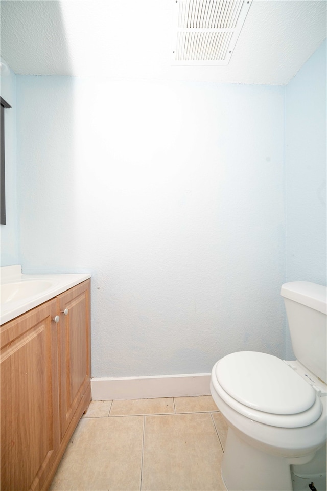 bathroom featuring tile patterned floors, vanity, a textured ceiling, and toilet