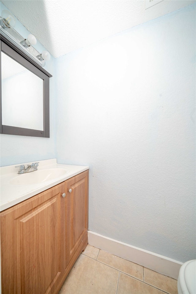 bathroom featuring tile patterned floors, vanity, and toilet