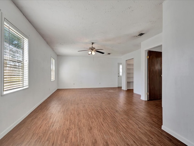 spare room with hardwood / wood-style flooring, ceiling fan, and a textured ceiling