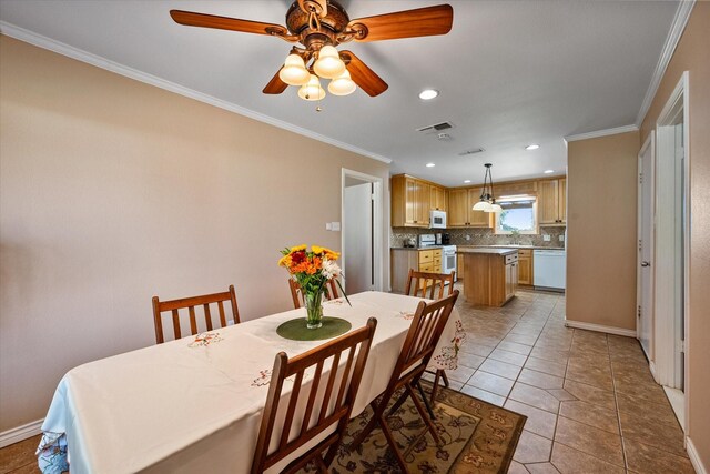 dining room with ceiling fan, crown molding, light tile patterned flooring, and sink