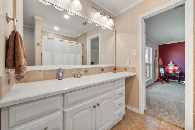 bathroom with crown molding, tile patterned flooring, and vanity