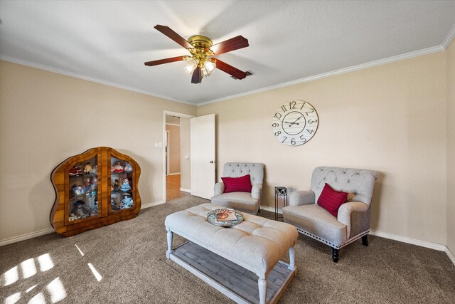 sitting room with ceiling fan, carpet floors, and crown molding