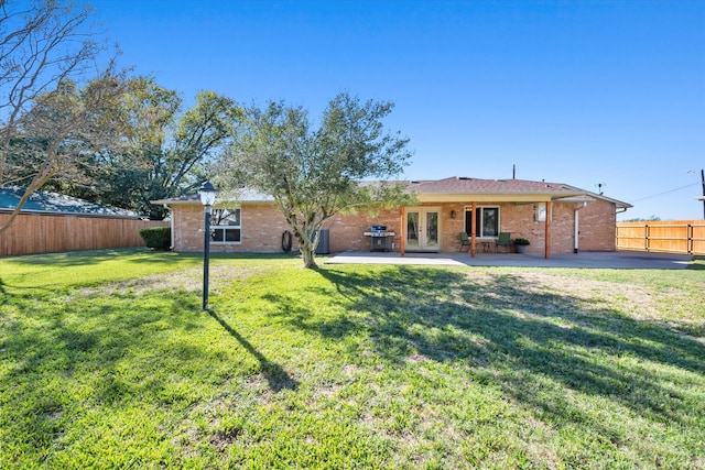 back of property featuring french doors, a yard, and a patio