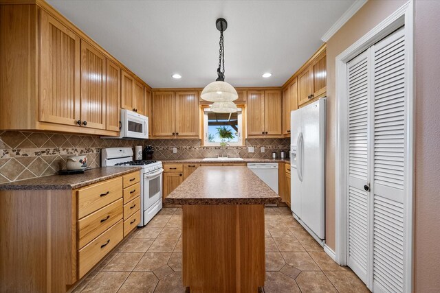 kitchen featuring sink, hanging light fixtures, backsplash, white appliances, and a kitchen island