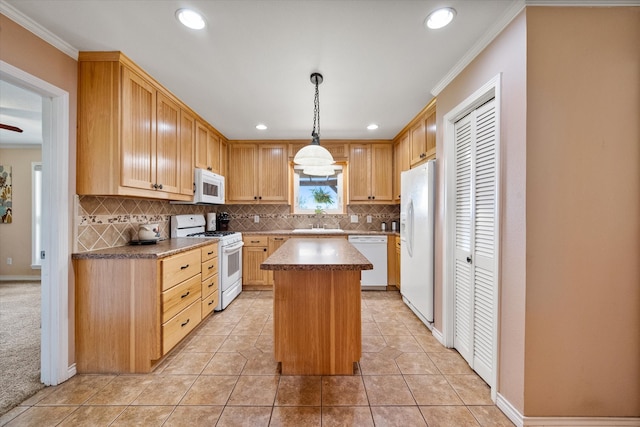 kitchen featuring white appliances, crown molding, sink, pendant lighting, and a center island