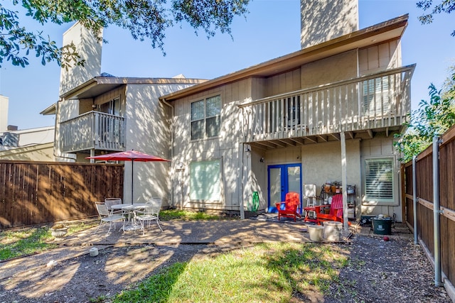 rear view of house featuring a patio area and a balcony