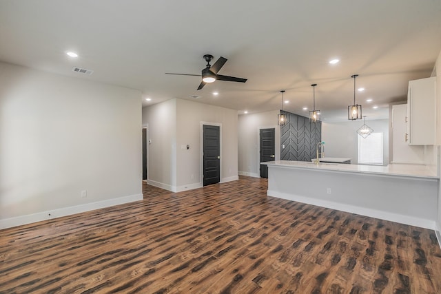 unfurnished living room with ceiling fan and dark wood-type flooring