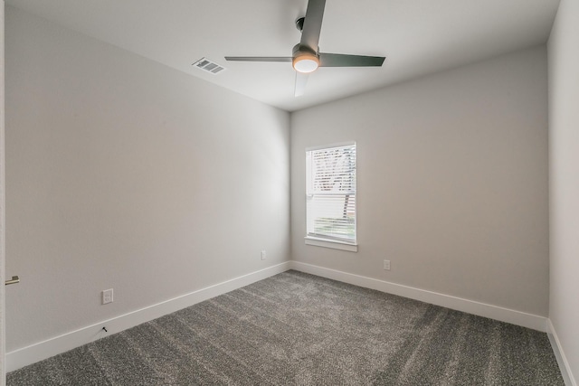 empty room with ceiling fan and dark carpet