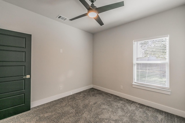 empty room with ceiling fan, a wealth of natural light, and carpet flooring