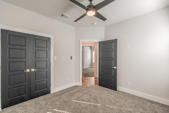 unfurnished bedroom with ceiling fan, a closet, and carpet floors