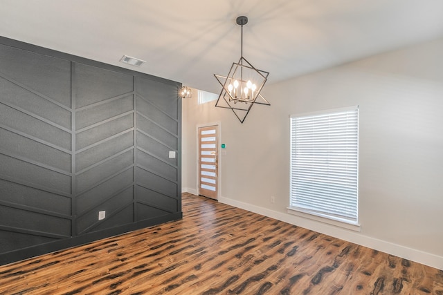 unfurnished room featuring a chandelier and hardwood / wood-style floors