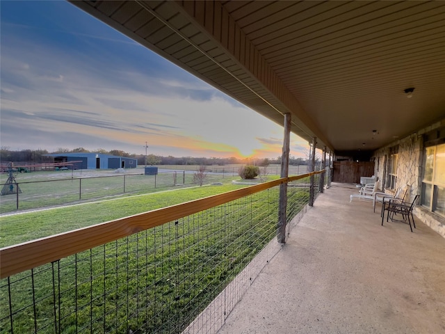 patio terrace at dusk with a lawn and a rural view