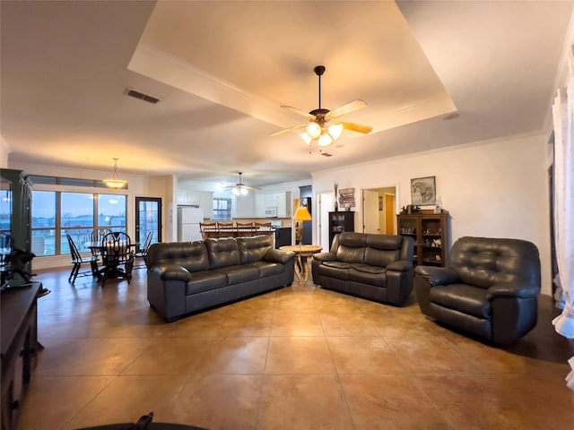 tiled living room featuring a raised ceiling and ceiling fan