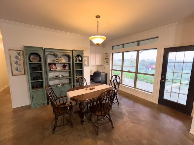 dining space with dark tile patterned floors and ornamental molding