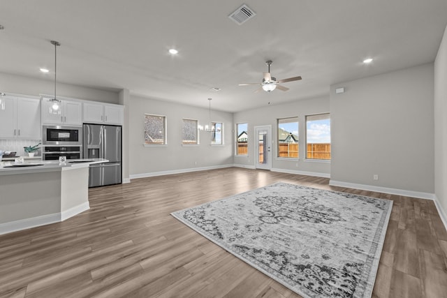 living room featuring recessed lighting, wood finished floors, visible vents, baseboards, and a ceiling fan