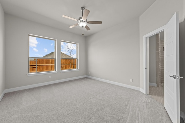 spare room with baseboards, a ceiling fan, and light colored carpet