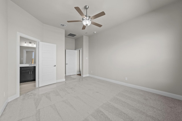 unfurnished bedroom with visible vents, ensuite bath, light carpet, and baseboards