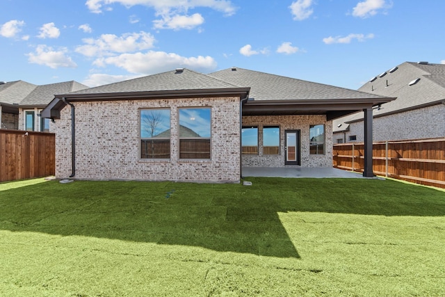 back of house featuring a patio area, a fenced backyard, a shingled roof, and brick siding