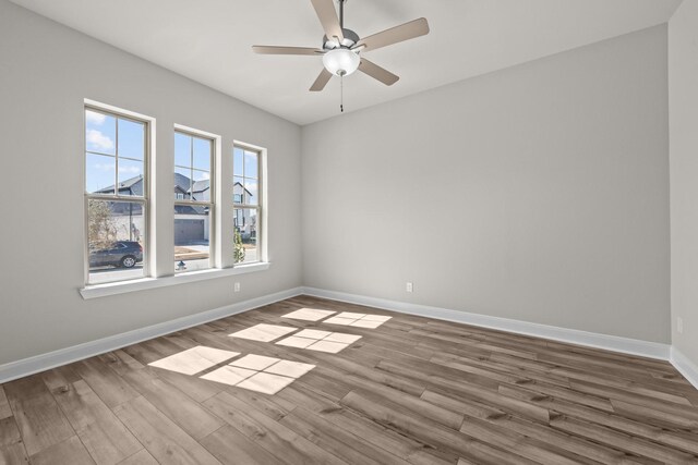 empty room featuring light wood-type flooring, ceiling fan, and baseboards