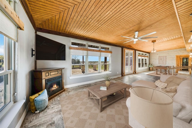 living room with ceiling fan, plenty of natural light, wood ceiling, and wooden walls