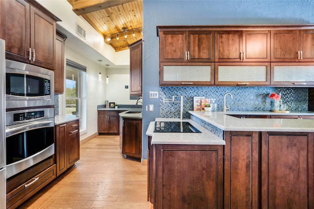 kitchen with wooden ceiling, stainless steel appliances, light wood-type flooring, vaulted ceiling with beams, and sink