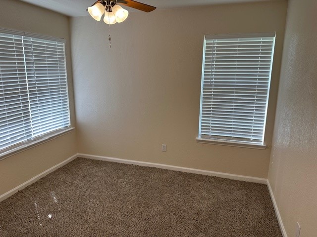 carpeted spare room featuring ceiling fan