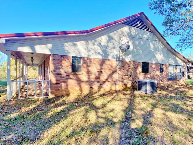 view of side of property with a yard and central AC unit