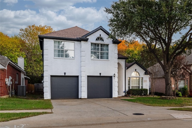 view of front of property with cooling unit, a garage, and a front yard