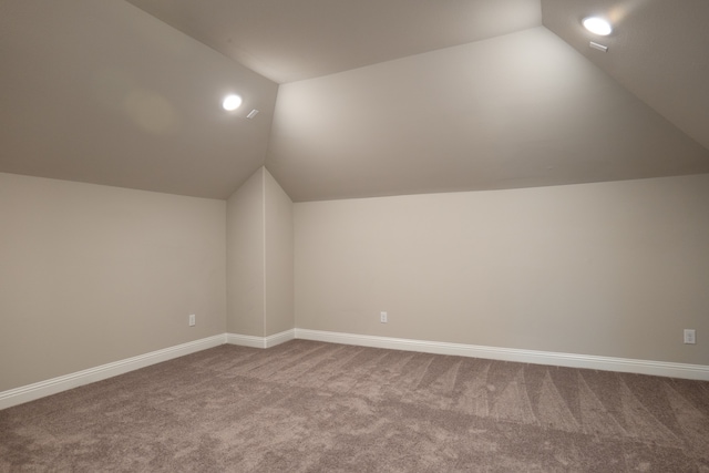 additional living space with carpet flooring and vaulted ceiling