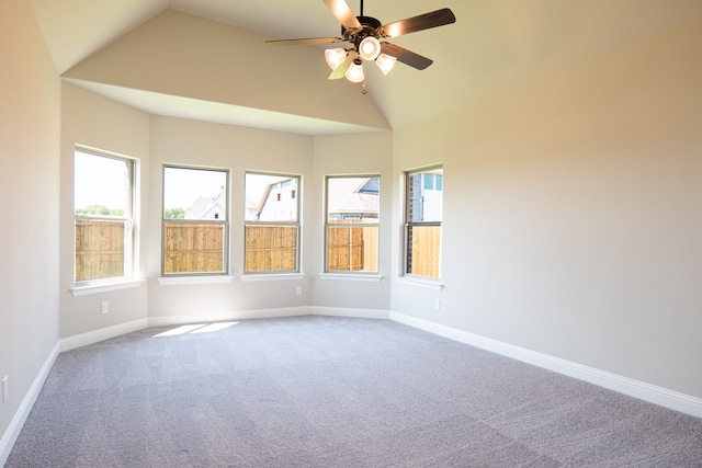 carpeted spare room with ceiling fan and vaulted ceiling