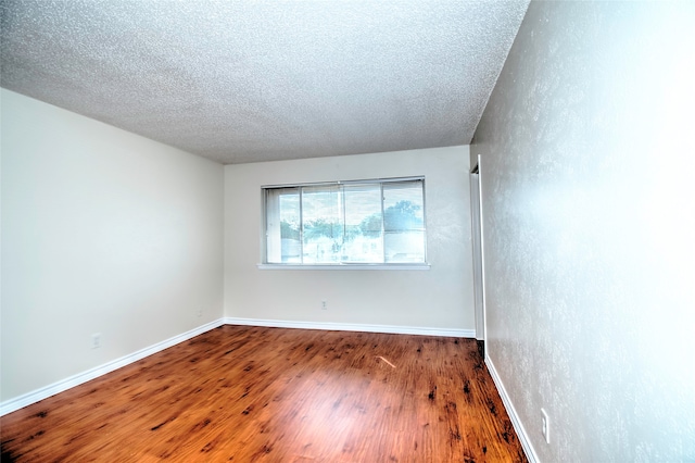 unfurnished room featuring a textured ceiling and dark wood-type flooring