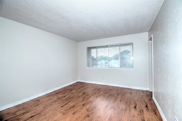 spare room featuring hardwood / wood-style floors and a textured ceiling