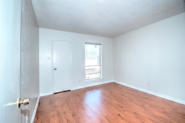 unfurnished room featuring a textured ceiling and hardwood / wood-style flooring