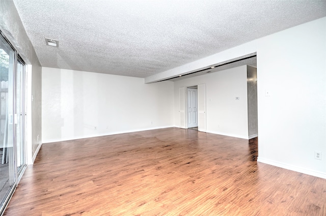 spare room featuring hardwood / wood-style floors and a textured ceiling