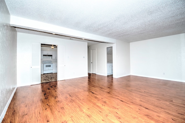 unfurnished room with wood-type flooring and a textured ceiling