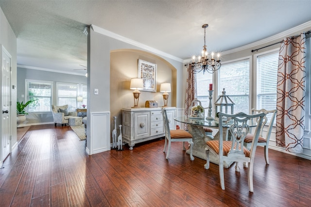 dining room featuring ceiling fan with notable chandelier, dark hardwood / wood-style flooring, ornamental molding, and a textured ceiling