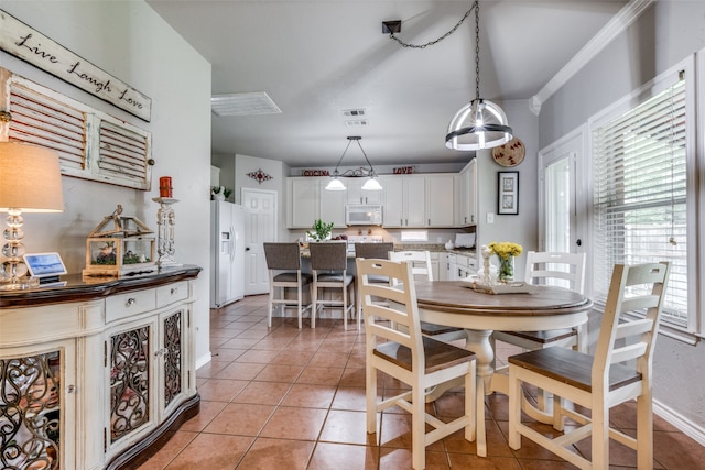 dining room with light tile patterned floors and ornamental molding