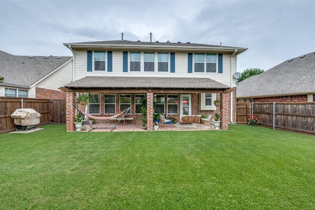 rear view of house featuring a patio area, brick siding, a fenced backyard, and a lawn