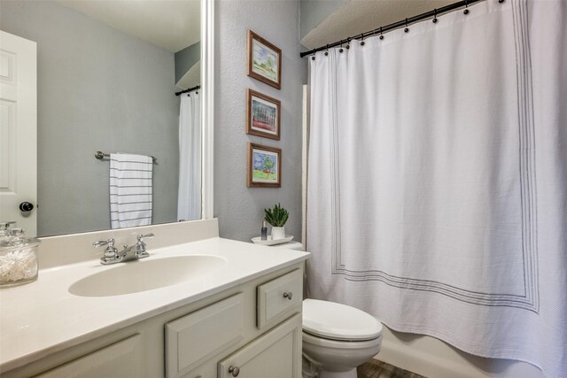 bathroom with hardwood / wood-style floors, vanity, and tiled tub