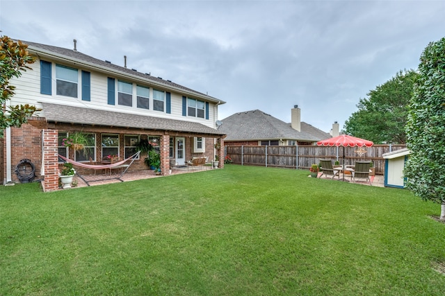 back of property featuring a lawn and a patio area