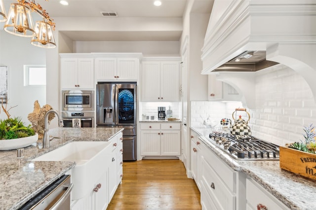 2005 Tremont Blvd, Mckinney, TX 75071 - kitchen with stainless steel appliances, premium range hood, white cabinetry, tasteful backsplash, and recessed lighting